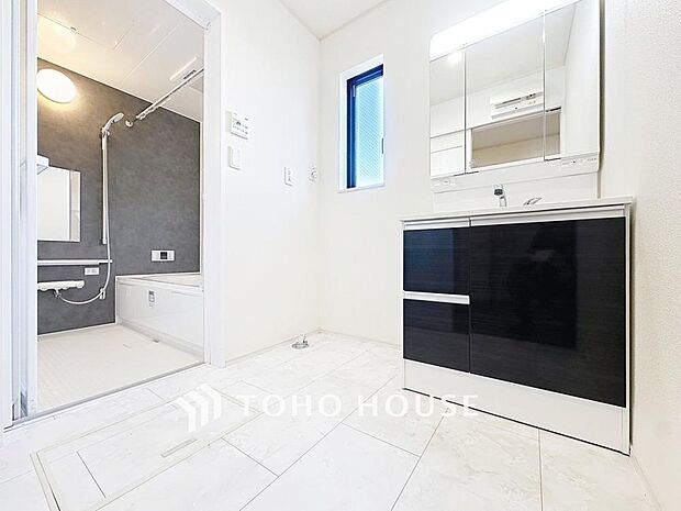 「清潔な印象の洗面室」明るく清潔感のある色調で纏められた洗面室は、機能性に富んだ三面鏡と使い勝手の良い収納を完備した洗面台を設置。洗濯機置場も完備し、大変充実しております。