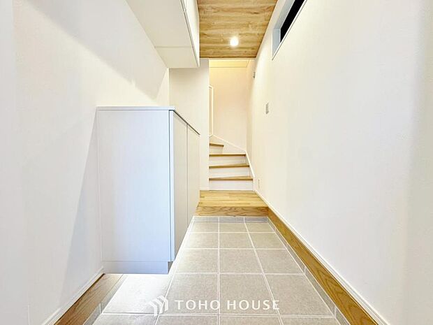 「足元を照らす玄関。」ホワイトを基調とした玄関。大きなインテリアや色味のあるアートを足すことで、寂しさを感じさせず洗練された空間を演出してくれます。