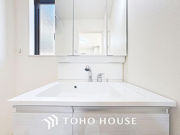 「洗面化粧台」清潔感溢れるデザインの洗面化粧台です。三面鏡の裏側や足元のキャビネットなど、収納豊富で実用的な洗面空間です。