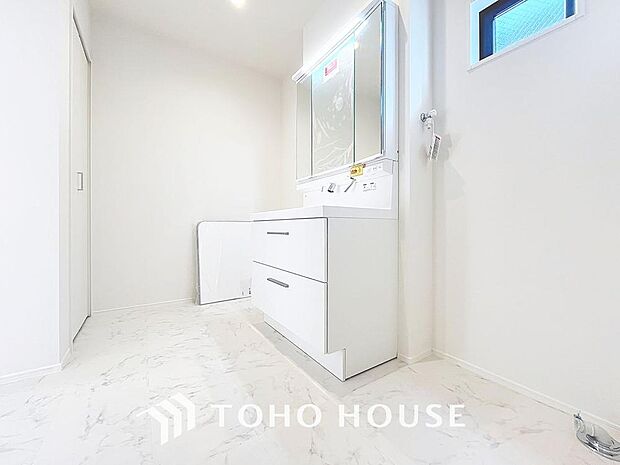 「清潔な印象の洗面室」明るく清潔感のある色調で纏められた洗面室は、機能性に富んだ三面鏡と使い勝手の良い収納を完備した洗面台を設置。洗濯機置場も完備し、大変充実しております。