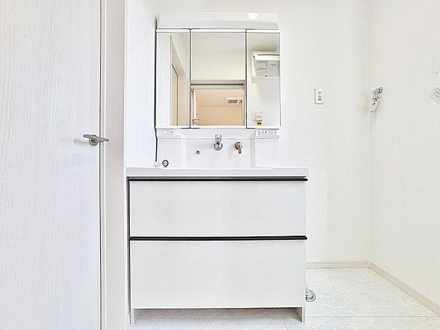 「清潔な印象の洗面室」明るく清潔感のある色調で纏められた洗面室は、機能性に富んだ三面鏡と使い勝手の良い収納を完備した洗面台を設置。洗濯機置場も完備し、大変充実しております。