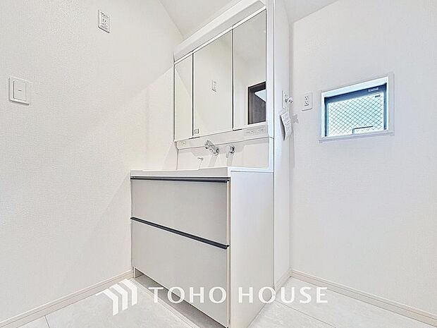 「清潔な印象の洗面室」明るく清潔感のある色調で纏められた洗面室は、機能性に富んだ三面鏡と使い勝手の良い収納を完備した洗面台を設置。洗濯機置場も完備し、大変充実しております。