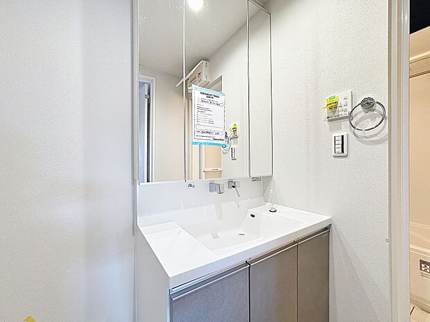 「清潔な印象の洗面室」明るく清潔感のある色調で纏められた洗面室は、機能性に富んだ三面鏡と使い勝手の良い収納を完備した洗面台を設置。洗濯機置場も完備し、大変充実しております。