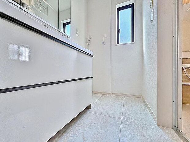 「清潔な印象の洗面室」明るく清潔感のある色調で纏められた洗面室は、機能性に富んだ三面鏡と使い勝手の良い収納を完備した洗面台を設置。洗濯機置場も完備し、大変充実しております。