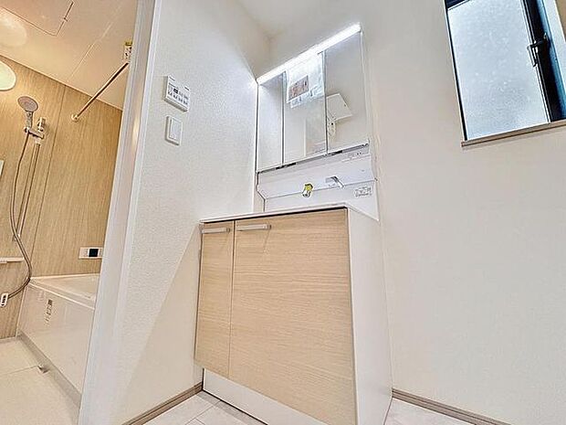 「清潔な印象の洗面室」明るく清潔感のある色調で纏められた洗面室は、機能性に富んだ三面鏡と使い勝手の良い収納を完備した洗面台を設置。洗濯機置場も完備し、大変充実しております。