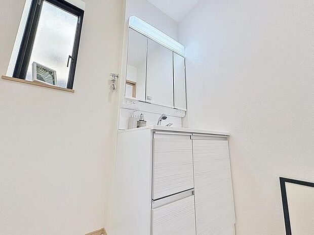 「清潔な印象の洗面室」明るく清潔感のある色調で纏められた洗面室は、機能性に富んだ三面鏡と使い勝手の良い収納を完備した洗面台を設置。洗濯機置場も完備し、大変充実しております。