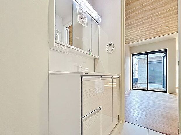 「清潔な印象の洗面室」明るく清潔感のある色調で纏められた洗面室は、機能性に富んだ三面鏡と使い勝手の良い収納を完備した洗面台を設置。洗濯機置場も完備し、大変充実しております。