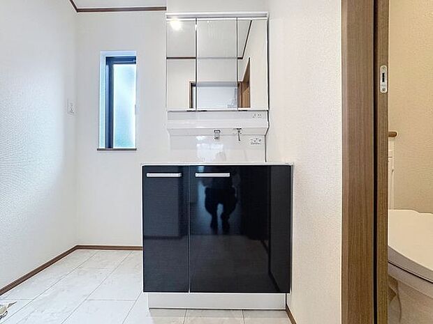 「清潔な印象の洗面室」明るく清潔感のある色調で纏められた洗面室は、機能性に富んだ三面鏡と使い勝手の良い収納を完備した洗面台を設置。洗濯機置場も完備し、大変充実しております。