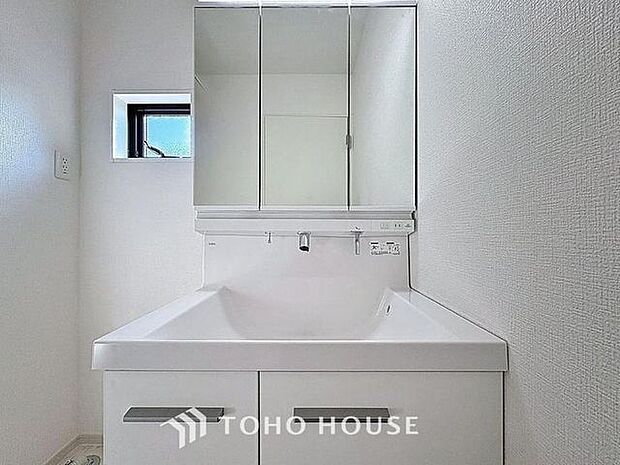 「清潔な印象の洗面室」明るく清潔感のある色調で纏められた洗面室は、機能性に富んだ三面鏡と使い勝手の良い収納を完備した洗面台を設置。洗濯機置場も完備し、大変充実しております。