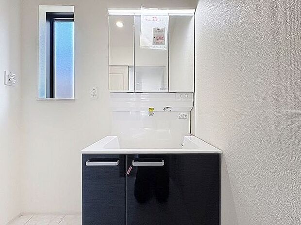 「清潔な印象の洗面室」明るく清潔感のある色調で纏められた洗面室は、機能性に富んだ三面鏡と使い勝手の良い収納を完備した洗面台を設置。洗濯機置場も完備し、大変充実しております。