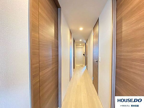 木目調の建具が映える廊下。廊下の途中には掃除用具などを入れられる収納もあります！（収納の中にはコンセントもあります）