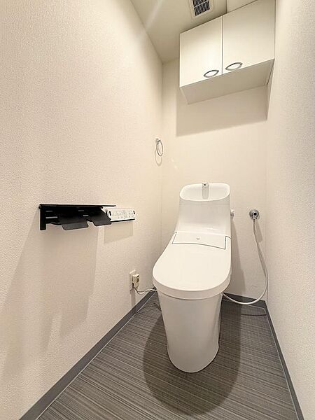 トイレは温水洗浄便座付！トイレットペーパーなどを置いておけるちょっとした可動棚もあります。