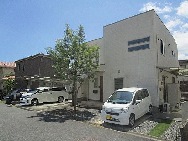 青空が広がる閑静な住宅街に佇む一戸建て。開放感のある立地で、駐車スペースも確保されています。ぜひ現地をご覧ください。