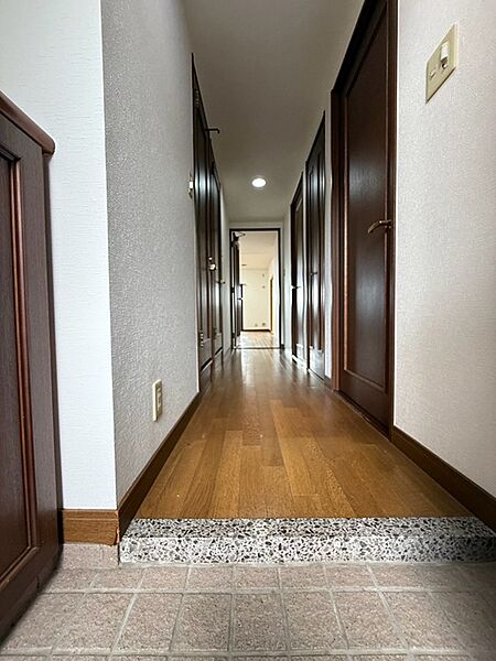 温かみのある木目調のフローリングと白い壁が調和し、住む人の心を落ち着かせる玄関。居住空間への期待感が高まります。