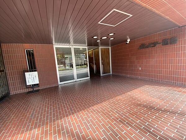 落ち着いた赤レンガ調の外壁が印象的なエントランス。大きなガラス扉から自然光が差し込み、明るく開放的な空間です。