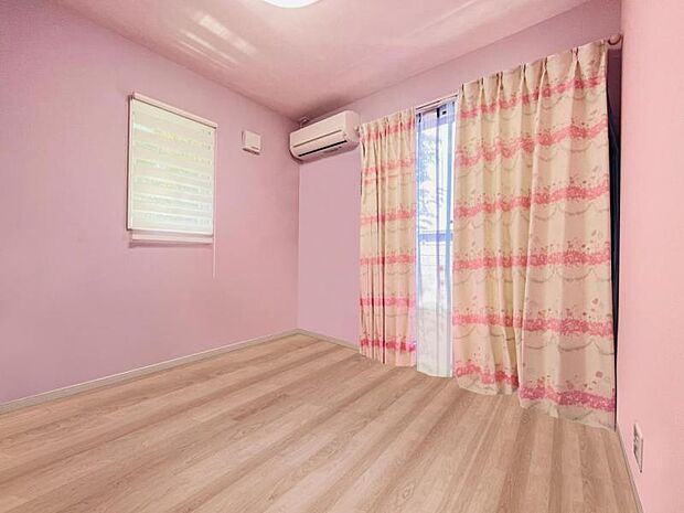 約4.5帖の洋室。ピンクの壁がかわいらしい印象。