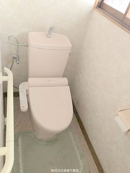 温水洗浄便座。トイレには手すりがついていて安心
