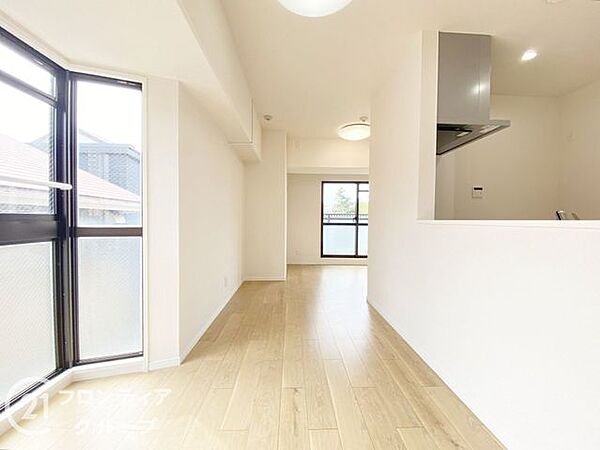 ナチュラルな木目調のフローリングと落ち着いたトーンのクロスが調和したリビング。大きな掃き出し窓が開放感を演出し、外の風景と心地よくつながります。家族との時間も一人の時間も楽しめる理想的な居住空間です。