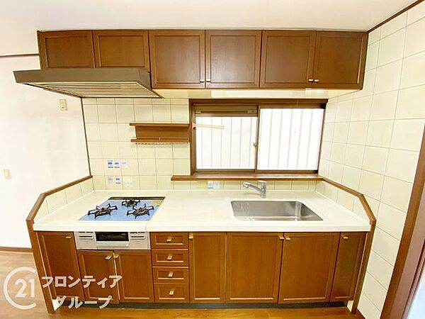 木の温もりを感じるデザインが、キッチンを家族の憩いの場に変えてくれますね！窓越しに外の景色を眺めながら作業ができるので、忙しい朝も気持ちが和らぎます。使い勝手の良い3口コンロも嬉しいポイントですね！
