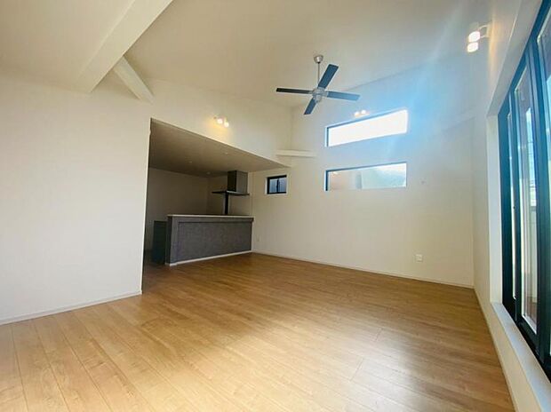 吹き抜け天井のため、空間が広く感じられます。窓からの光はリビングを明るく照らしてくれます。