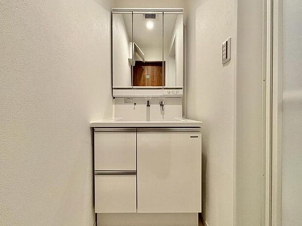 三面鏡の裏は機能的な収納を配置。コンセントも付いているため電動シェーバーや、電動歯ブラシも収納できます。