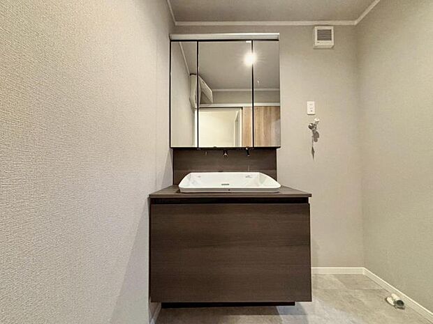 洗面室は、しっかりとしたスペースを確保。上質な温かみを持つカラーで統一されています。ワイドな洗面台は収納力もありいつでもすっきりとした洗面室に。