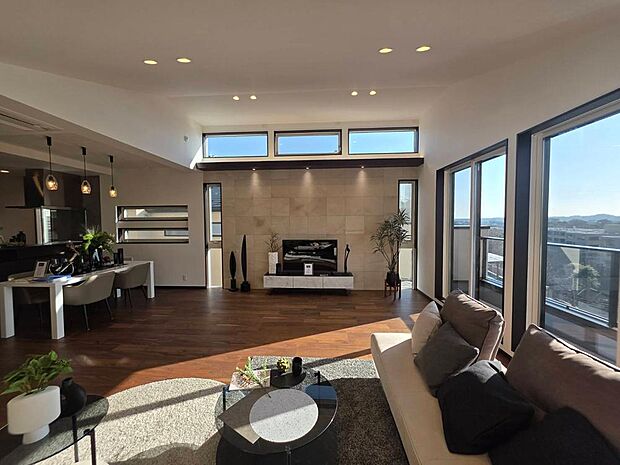 「A号棟」約30．15帖のLDKは勾配天井により広く感じられ多くの開口部から陽光が差し込みます。※ディスプレイされている家具等は価格に含まれません。