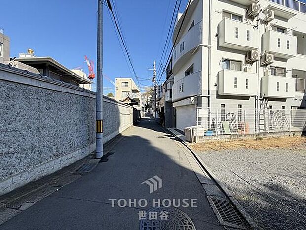 陽光が降り注ぐ、穏やかな通りに面した現地。周辺の建物と調和し、子育て世代にも安心の落ち着いた住環境が魅力です。