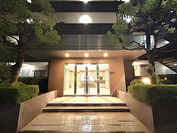 夜間も明るい照明が灯るエントランスアプローチです。植栽も綺麗に整えられており、管理体制の良さが窺えます。住まう方を優しく迎え入れるとともに、防犯面でも安心感を与える落ち着いた佇まいです。