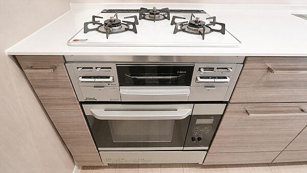 料理の幅が広がる充実設備。3口コンロ・グリル・食洗機を備えた機能的なシステムキッチン。