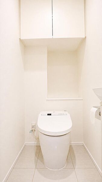 温水洗浄便座付きタンクレストイレ。収納も備えたすっきりとした空間。