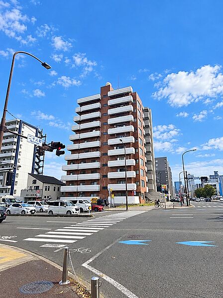 二十八人町交差点に面したマンション。青空が広がる開放的な立地で、毎日のお散歩も楽しめそう♪
