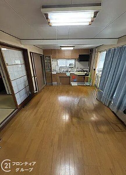 木目の美しさが際立つフローリングが、温かみのある空間を演出しています。隣接するお部屋との繋がりもあり、家族の気配を感じながらゆったりと過ごせる広々としたリビングダイニングです