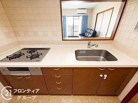木目調のパネルが温かみを添えるキッチンは、お料理の時間をより楽しく演出します。窓から差し込む柔らかな光を感じながら、ご家族のために腕を振るう豊かなひとときをお過ごしいただけます