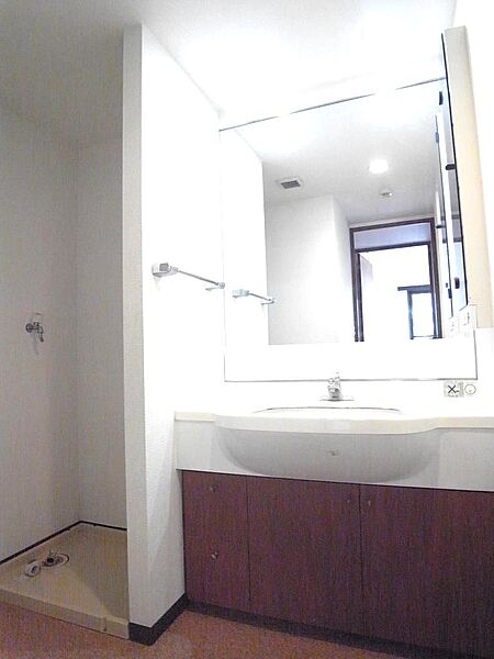 大きな鏡の洗面化粧台は、並んで歯磨きも可能。室内洗濯機置き場併設でも脱衣スペースは十分です