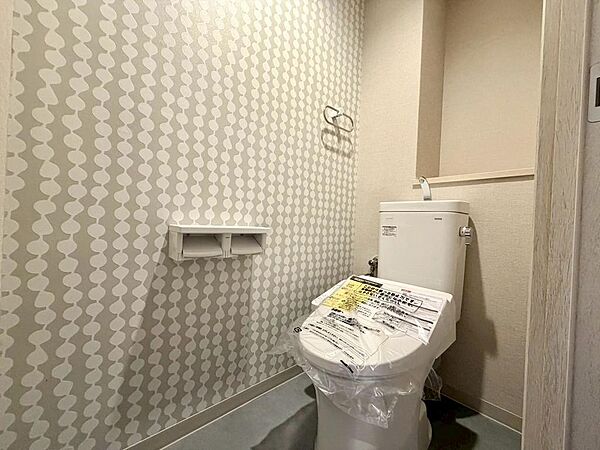 おしゃれなアクセントウォールで彩られたモダンなトイレです。温水洗浄器付便座も新調され明るく機能的に仕上がっています。