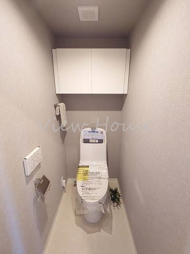 トイレットペーパー等の収納に便利な扉付きの棚がある清潔感のあるトイレ