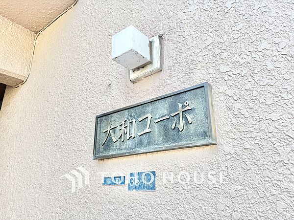 歴史と温かみを感じさせる「大和コーポ」の館銘板。どこか懐かしく、愛着の湧く佇まいです。