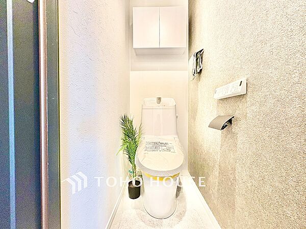 上部収納を備えた、すっきりとしたトイレ空間。日用品やストック類を収納しやすく、生活感を抑えて整った空間を保ちやすい設計です。