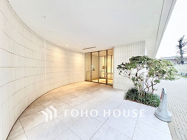 やわらかな曲線の壁面と美しい植栽が印象的なエントランスアプローチ。奥行きのある空間が居住者を優しく迎え入れます。