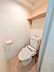 トイレ：清潔感あふれる白を基調としたトイレです。上部にはトイレットペーパーや備品の保管に重宝する木製の固定棚を設置。手洗い付きタンクや温水洗浄便座を備えており、快適に利用できる空間になっています。