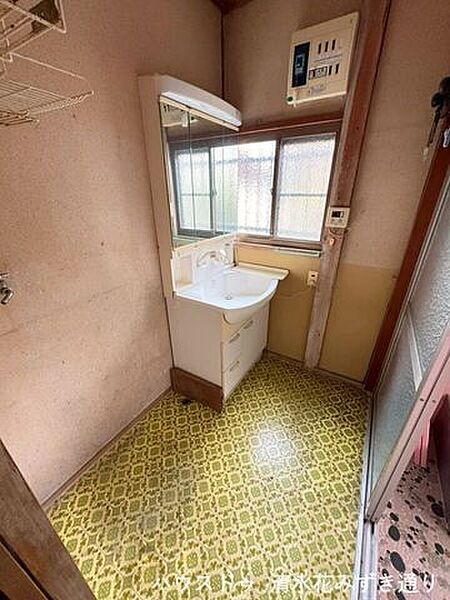 西側に小窓を備えた洗面所は、午後のやわらかな光が差し込む心地よい空間。タイル調のデザインがレトロな雰囲気を演出し、毎日の身支度時間も少し楽しくなるような、味わいのある洗面スペースです。