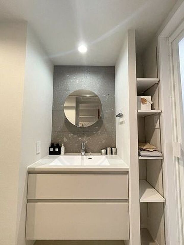 《洗面室》札幌軟石が施された洗面スペース。軟石の質感とホワイトに統一された洗面台はスタイリッシュな印象です。