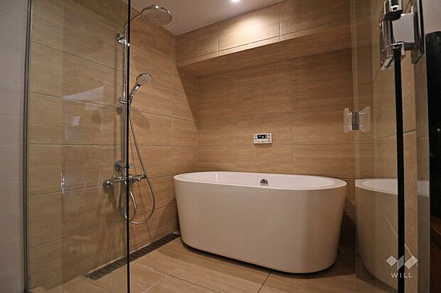 浴室は1620サイズ相当で、ゆとりのある空間。サンワ製の浴槽は移動させて掃除が可能。オーバーヘッドシャワーがラグジュアリーです。