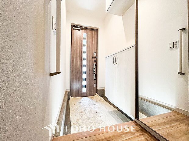 明るくコントラストのある、開放感と清潔感を兼ね備えた玄関。