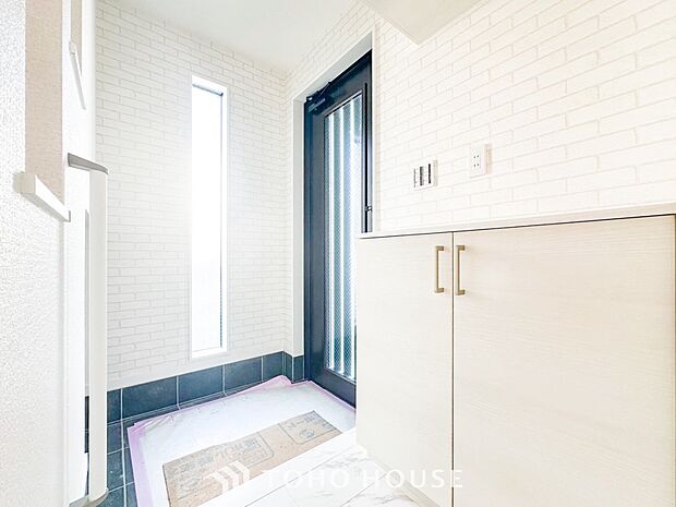 明るくコントラストのある、開放感と清潔感を兼ね備えた玄関。