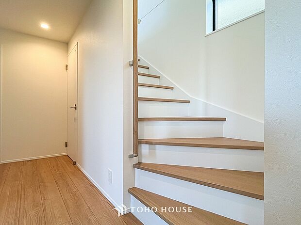 パブリックゾーンとプライベートゾーン繋ぐ階段。豊かな陽光が注ぎ込み、爽やかな住空間を演出。