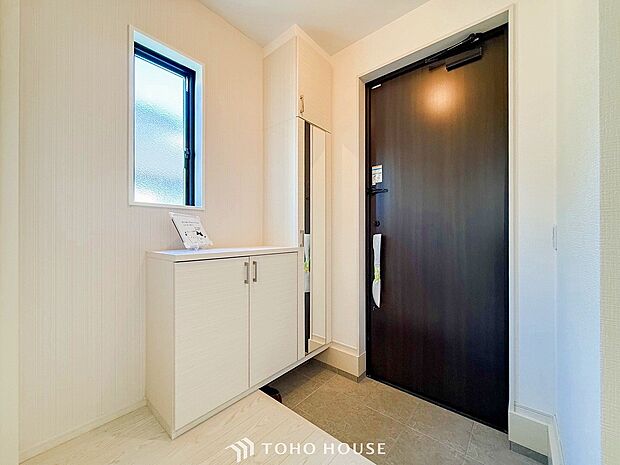 明るくコントラストのある、開放感と清潔感を兼ね備えた玄関。