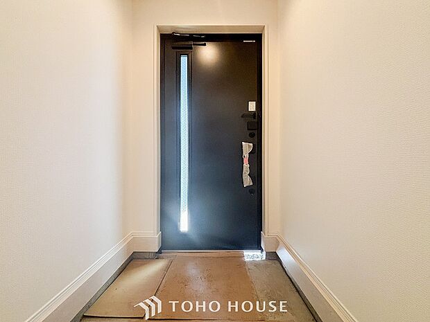 明るくコントラストのある、開放感と清潔感を兼ね備えた玄関。