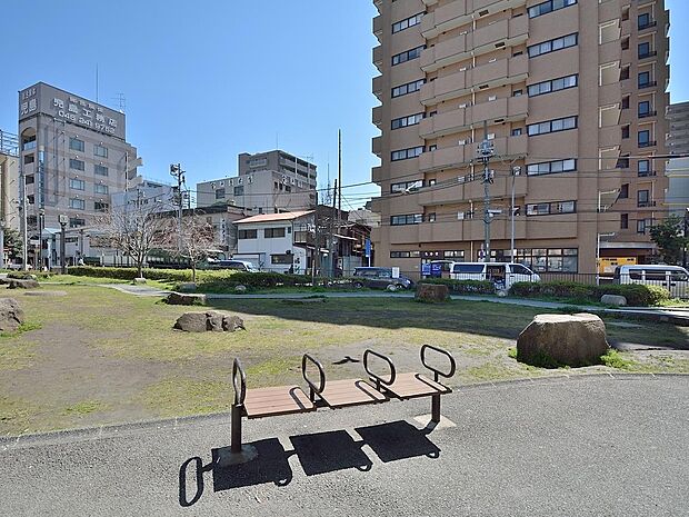 高速道路のランプが日陰の役割も果たしてくれる顔の形のマンホールベンチがある公園。